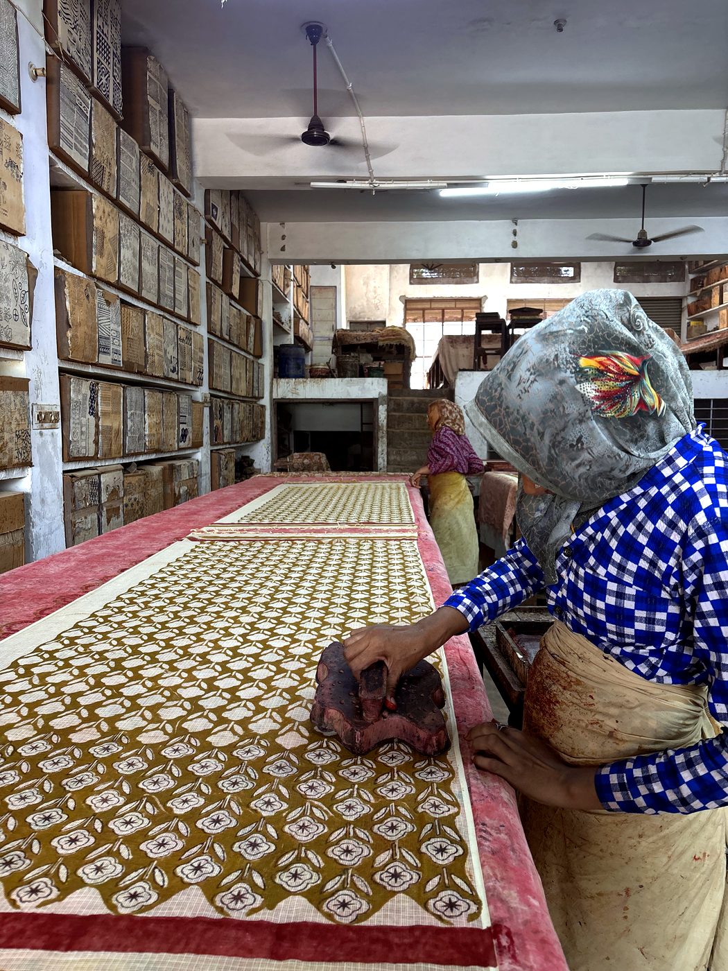 An artisan hand block printing fabric in the workshop