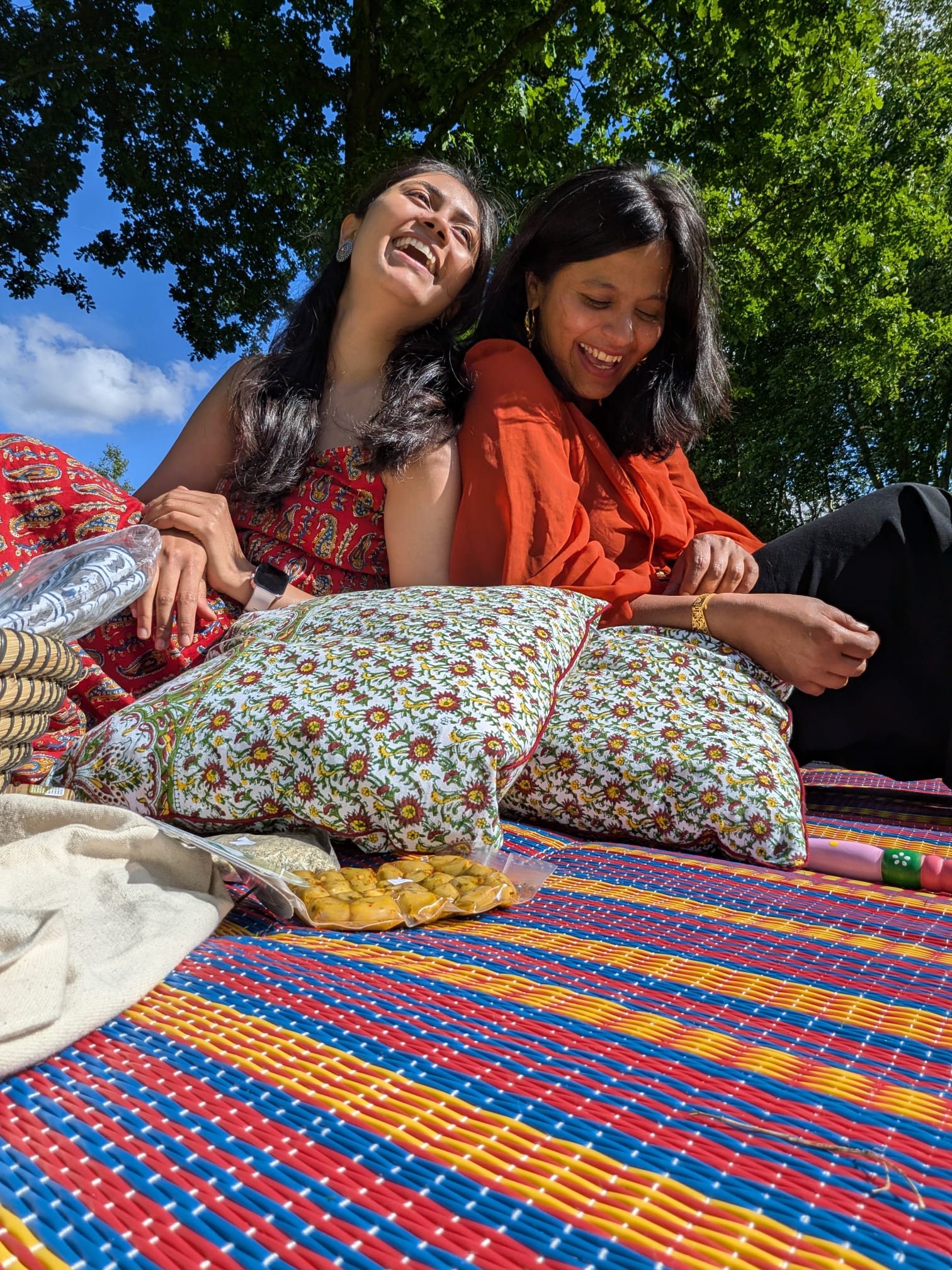 Dimple and Akkriti laughing at a picnic with Ghar cushions