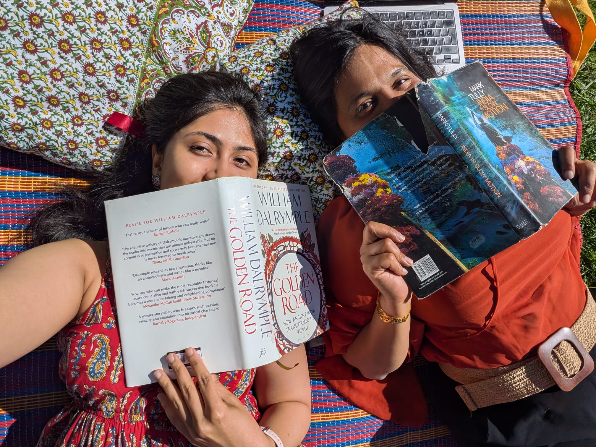 Reading books on a picnic mat surrounded by block printed cushions